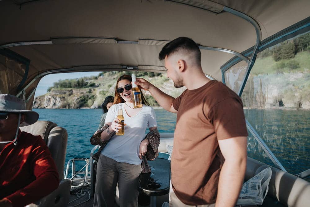 Image is of people drinking alcohol on a boat during a water outing, concept of a BUI lawyer reviewing boating under the influence allegations.