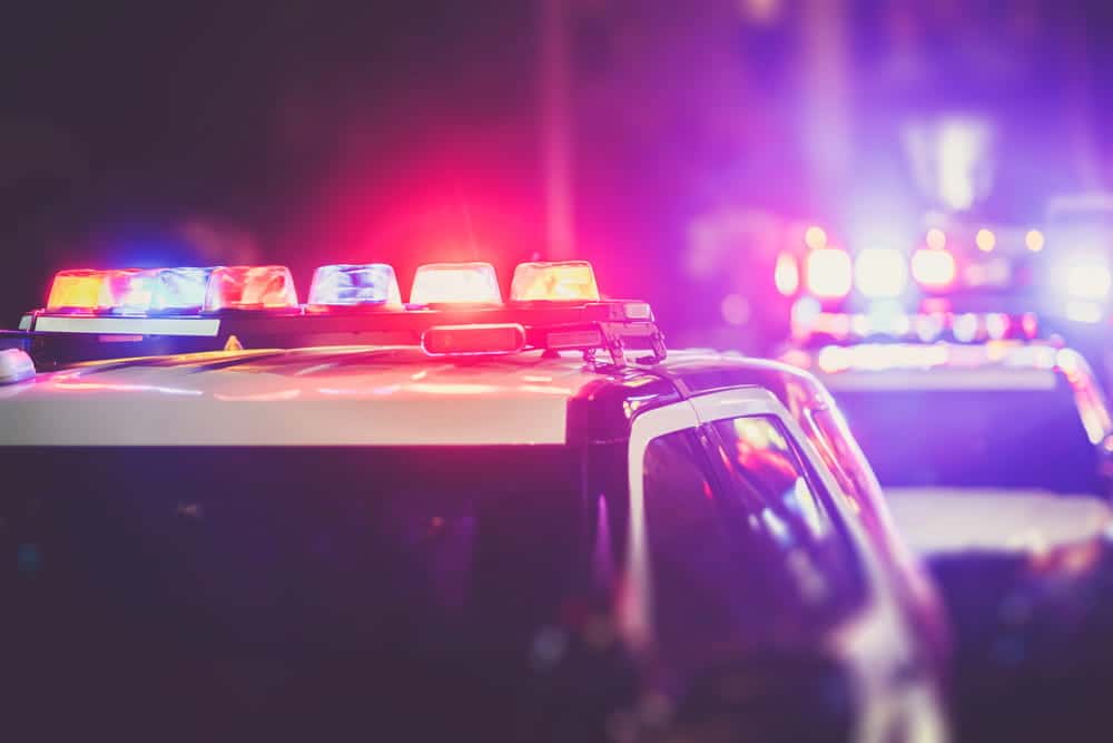Image is of police vehicle lights during an active investigation, concept of a criminal defense lawyer responding to criminal allegations