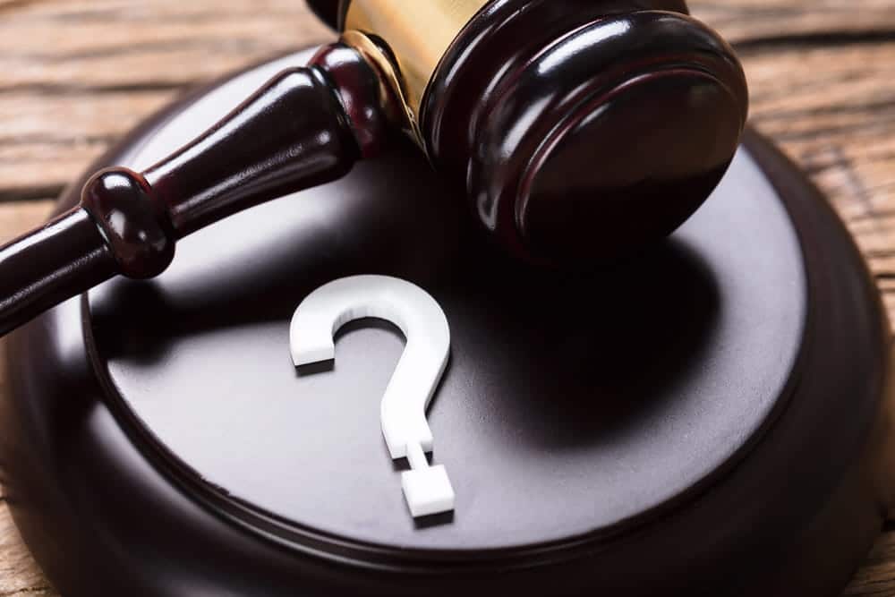 Image is of a gavel with a question mark on a sound block, concept of drug manufacturing lawyer evaluating legal uncertainty