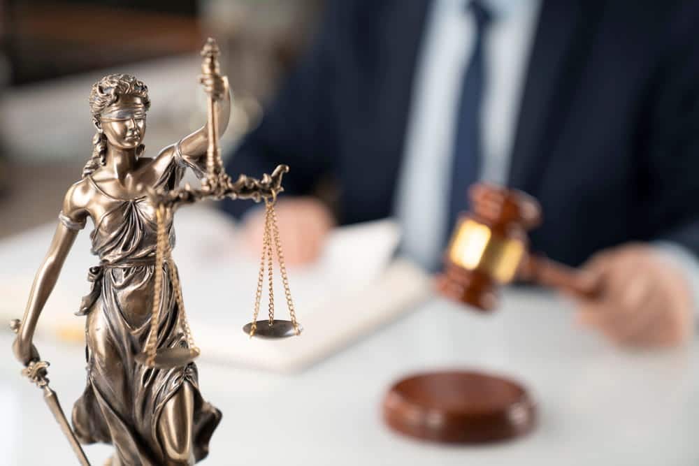 Image is of a Lady Justice statue with a gavel placed on a desk in a law office, concept of kidnapping lawyer