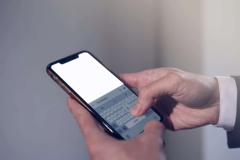 Image is of a person typing on a smartphone, representing digital messages and online interactions, concept of stalking and harassment lawyer analyzing communication evidence