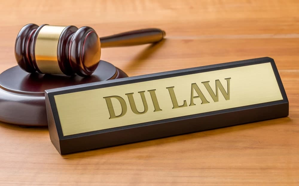 Image is of a DUI law sign with a judge’s gavel on a courtroom desk, concept of Clinton underage lawyer for DUI defense.