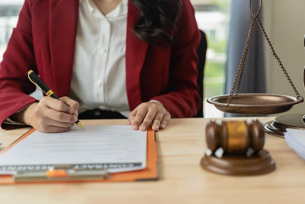 Image is of a lawyer signing legal documents at a desk, concept of violent crimes lawyer handling a case