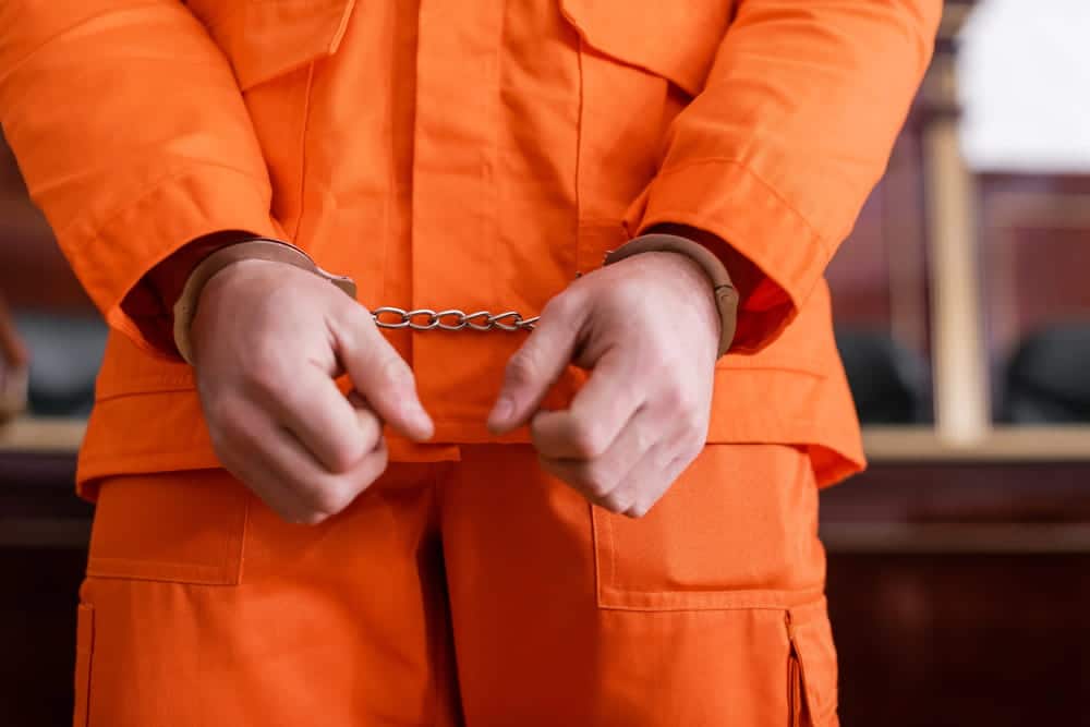 Image is of a person in handcuffs inside a courtroom, concept of Knoxville criminal defense lawyer.