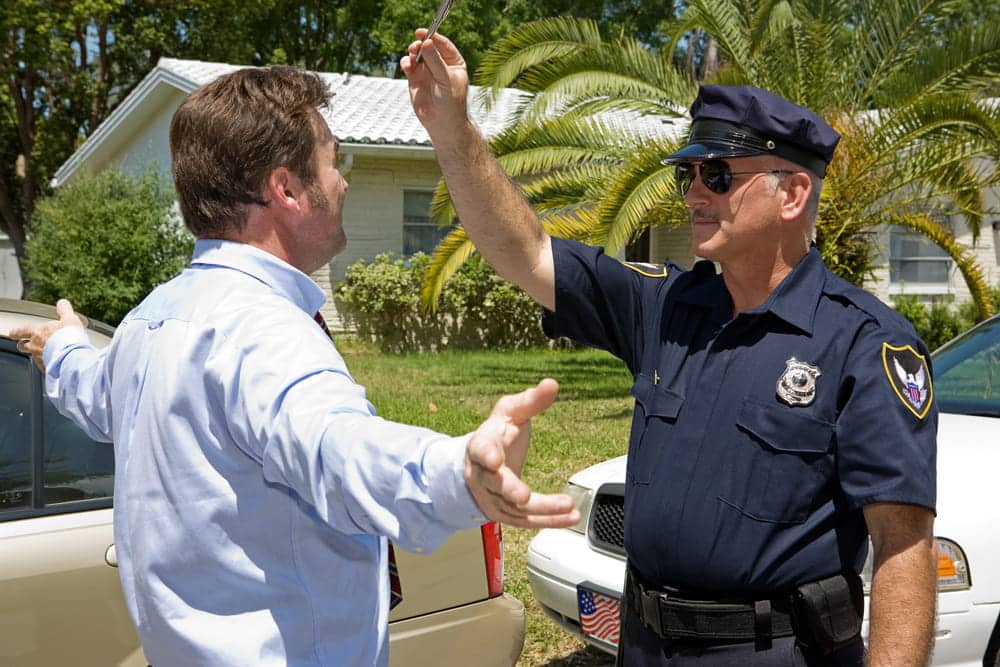 Image is of a police officer conducting a field sobriety test beside a vehicle, concept of Knoxville DUI defense lawyer.