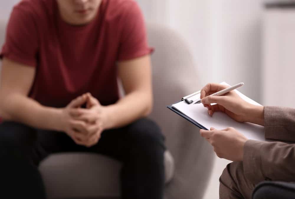 Image is of a person speaking with a professional during a diversion program, concept of drug possession charges and discussing possible legal consequences after an arrest.