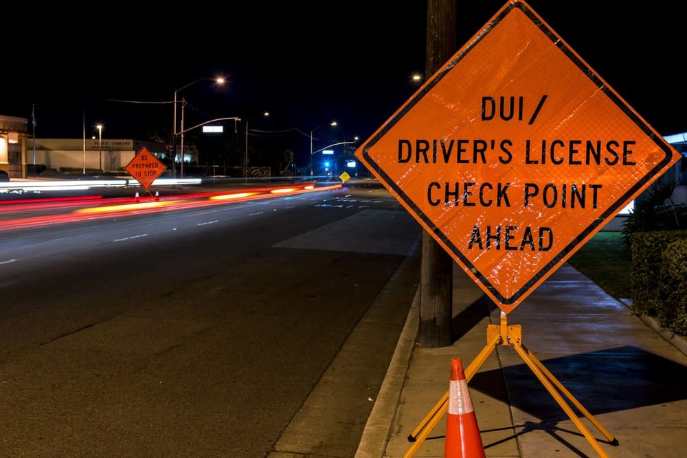 Image is of a roadside DUI checkpoint warning sign positioned ahead of traffic, concept of DUI checkpoints and public safety enforcement in Knoxville.