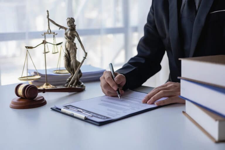 Image is of a lawyer reviewing legal documents beside a gavel and scales of justice, concept of a DUI felony in Tennessee