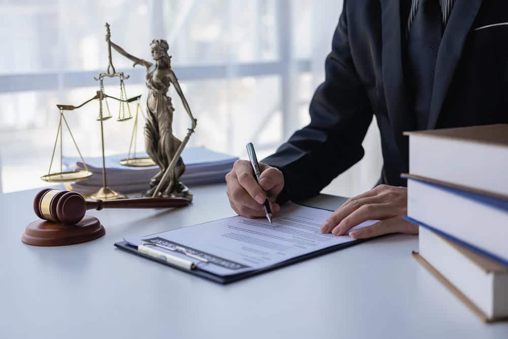 Image is of a lawyer reviewing legal documents beside a gavel and scales of justice, concept of a DUI felony in Tennessee