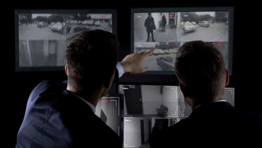 Image is of investigators reviewing surveillance camera footage, concept of theft under Tennessee law involving evidence used in a criminal investigation.