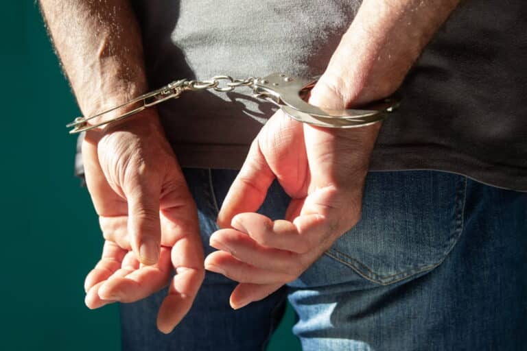 Image is of a person wearing handcuffs after an arrest, concept of a domestic violence arrest in Tennessee.