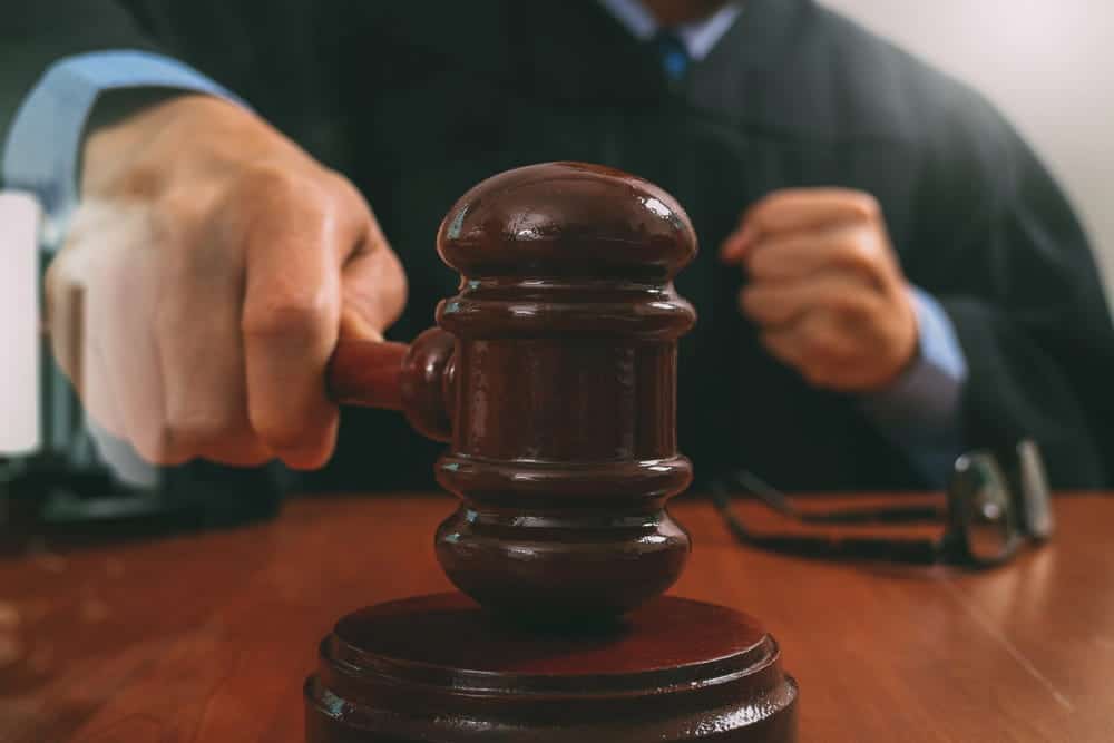 Image is of a judge using a gavel during court proceedings, concept of a domestic violence arrest and the court process in Tennessee.