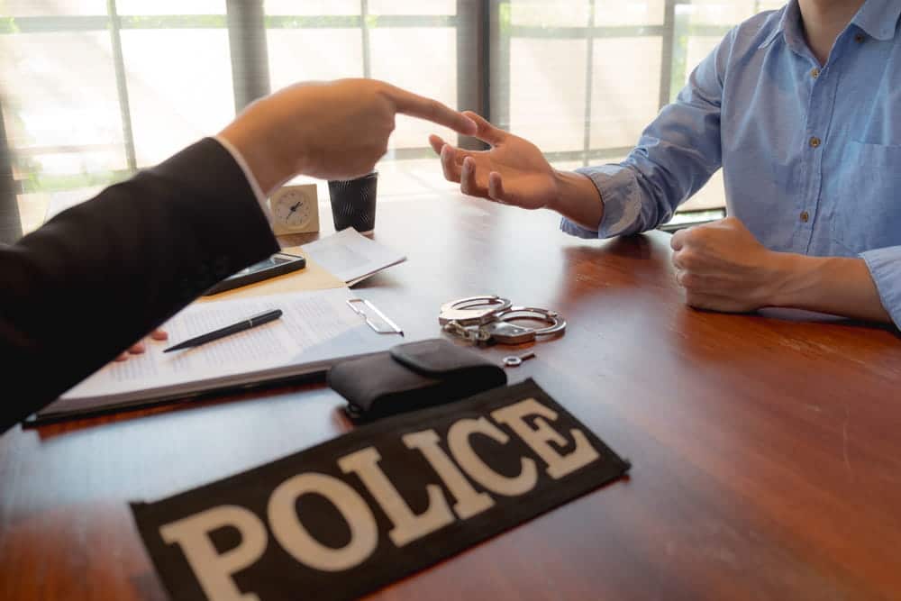 Image is of an attorney meeting with a client after a domestic violence arrest, explaining the legal process and next steps in Tennessee.