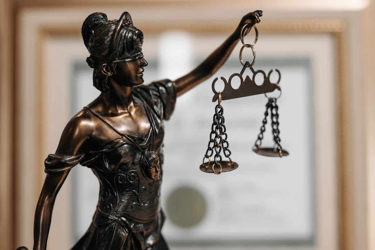 Image is of a Lady Justice statue holding scales, concept of legal consequences after an underage DUI in Knoxville