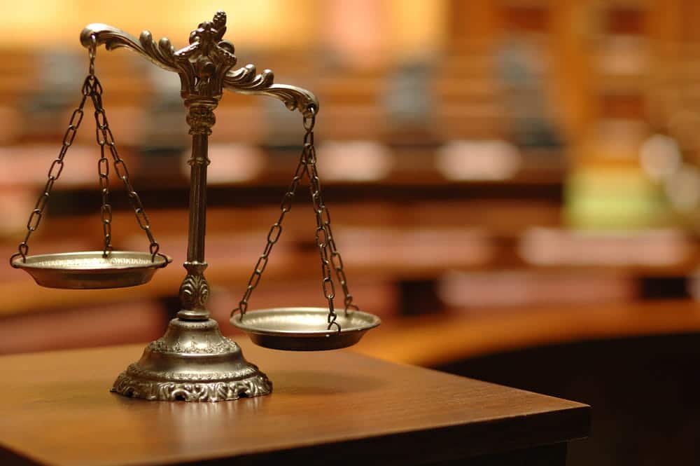 Image is of scales of justice inside a courtroom, representing the judicial process in a Tennessee drug case.